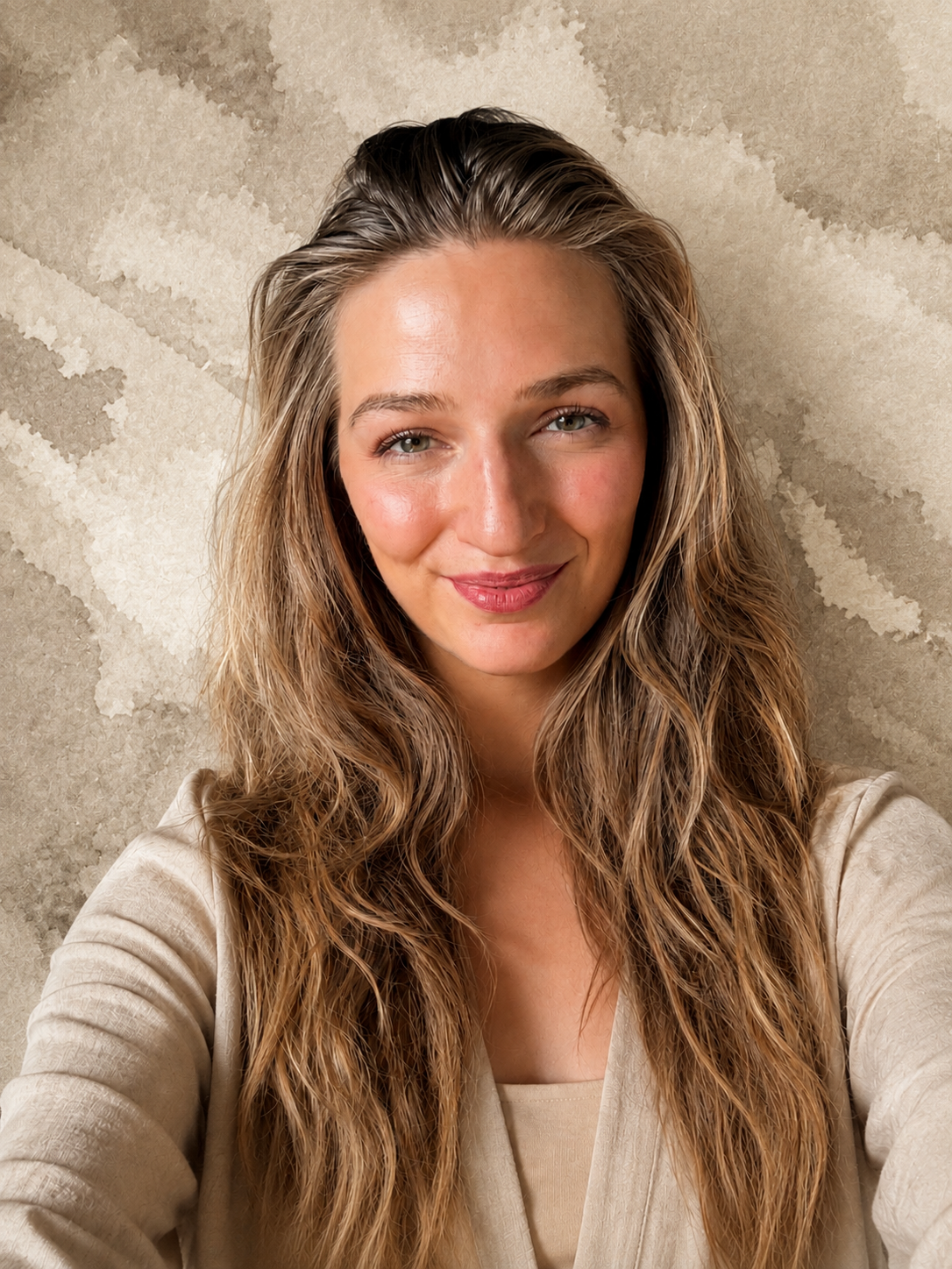 Portrait of Frauke smiling softly against a warm beige backdrop