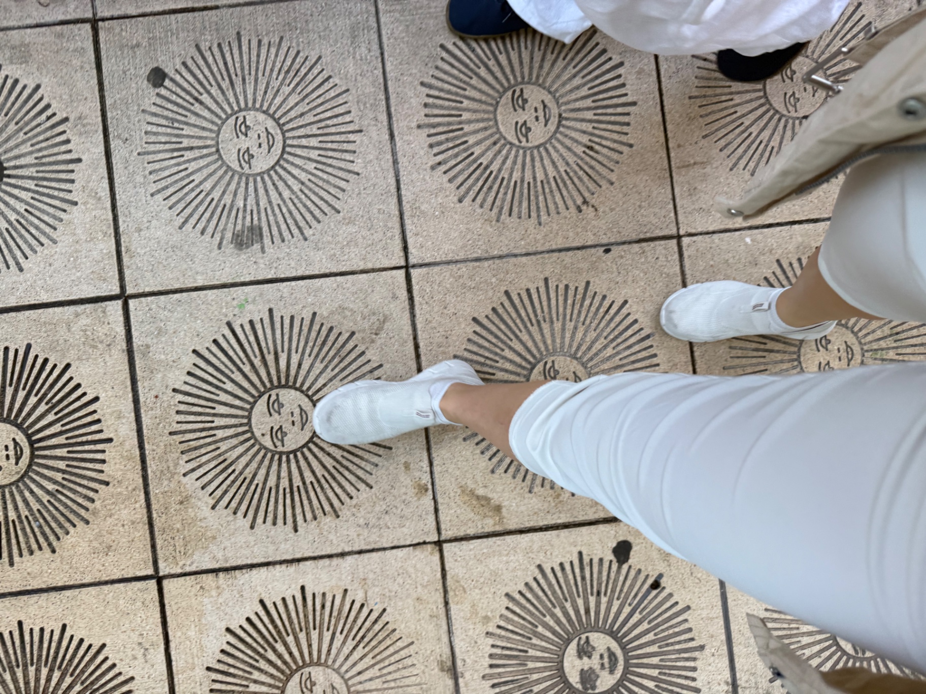Sun motifs carved into pale stone tiles underfoot